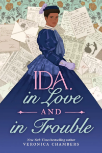 Illustrated cover of Ida, in Love and in Trouble. A young Black woman, Ida B. Wells, looks confidently over her shoulder at the viewer. She is wearing what's probably a dark blue, late 1800s dress. It has puffy sleeves, and she is wearing a coordinating little hat with a lavender accent and lavender gloves. She as a fountain pen in one hand. She is framed by scattered newspapers and letters.