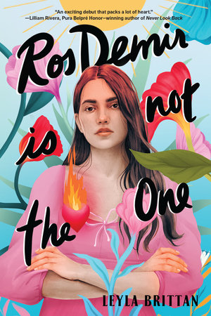 Young woman with slightly wavy brown hair past her shoulders has her arms crossed. She's wearing a pink shirt with a small bow in the center. There are brightly colored large flowers behind her and a flame is floating above her chest on the left side. She is staring out at the viewer with a serious look.