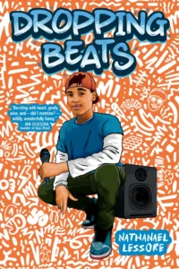 Cover featuring a young man with brown skin. He's holding a mic and wearing a red cap with the bill at the back of his head. He has a blue tshirt on over a long sleeved white shirt. He has dark long pants and blue tennis shoes on. There is a speaker behind him and the background looks almost like white graffiti on an orange wall.