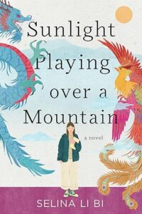 A young girl in a green jacket is standing in the center of the book. On the left is a blue dragon with a red belly. On the right is an orange phoenix.
