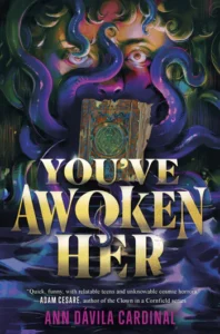The book cover for You've Awoken Her. The top of a face is peering from behind purple octopus arms. There is a golden and multicolored book in the area where the person's mouth would be. There are waves all around the golden title.