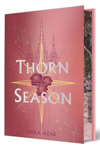 The cover of the book Thorn Season has an eight pointed gold star with three red roses in the center. Behind on the pink cover is a light drawing of a fancy building. The edges of the pages have a design on it.