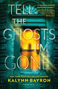 Book cover for Tell the ghosts I'm gone. There's an old styled building that has a sea green cast to it. A window is at the center of the cover. There are hands on the window inside but there is a golden back light so the figure is hazy.